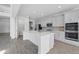 Modern, all-white kitchen featuring stainless appliances, an island, and a pantry at 5067 Northern Dove Ave, Mount Dora, FL 32757