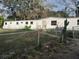 Single-wide mobile home with a chain link fence and a cactus at 5149 Bryant Ave, Sanford, FL 32773