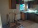 The kitchen features dated cabinets, laminate countertops, a window over the sink, and a damaged wood-look floor at 5149 Bryant Ave, Sanford, FL 32773
