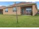 House's backyard with covered patio, grassy area, and a tree at 603 Lazio Cir, Debary, FL 32713