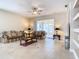 Spacious living room with tile floors, ceiling fan, and access to a screened porch at 6808 Cherry Grove Cir, Orlando, FL 32809