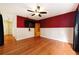 Hardwood floor bedroom with red walls and ceiling fan at 749 Silver Birch Pl, Longwood, FL 32750