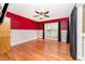 Bright bedroom with hardwood floors, ceiling fan, and red walls at 749 Silver Birch Pl, Longwood, FL 32750