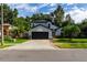 Two-story house with a gray exterior, black garage door, and landscaped yard at 749 Silver Birch Pl, Longwood, FL 32750
