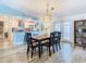 Farmhouse dining room with wood table, black chairs, and view to kitchen at 7779 Murcott Cir, Orlando, FL 32835