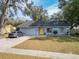 Cute blue house with yellow door, paved driveway, and landscaped yard at 7779 Murcott Cir, Orlando, FL 32835