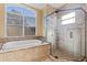 Spa-like bathroom with soaking tub, glass shower, and large window at 11359 Willow Gardens Dr, Windermere, FL 34786