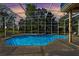 Enclosed pool area at sunset, with brick pavers and lounge chairs at 11359 Willow Gardens Dr, Windermere, FL 34786