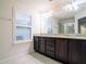 Bathroom with dark brown double vanity and granite countertop at 1164 Pavia Dr, Apopka, FL 32703