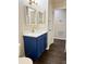 Modern bathroom with blue vanity, quartz countertop, and gold fixtures at 118 Mandrake St, Orlando, FL 32811