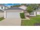 Cute pink house with a white garage door and well-maintained lawn at 120 Casterton Cir, Davenport, FL 33897