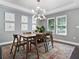 Modern dining room with wood table, six chairs, and a statement chandelier at 1375 Suffolk Rd, Winter Park, FL 32789