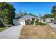 Tan one-story house with a green door, two-car garage, and manicured landscaping at 140 Rangeline Woods Cv, Longwood, FL 32750