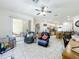 Open living room with access to the kitchen and patio, featuring a ceiling fan at 140 Rangeline Woods Cv, Longwood, FL 32750