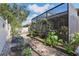 A garden area with a brick paver walking path and raised garden beds near screened in patio at 1721 Lakelet Loop, Oviedo, FL 32765