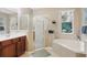 Modern bathroom featuring a soaking tub, walk-in shower with glass doors, and dual vanities at 1721 Lakelet Loop, Oviedo, FL 32765