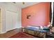 Cozy bedroom with wood floors, pink accent wall, and a comfortable bed and closet at 1721 Lakelet Loop, Oviedo, FL 32765