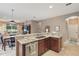 Modern kitchen with granite countertops, stainless steel appliances, and a view of the living and dining area at 1721 Lakelet Loop, Oviedo, FL 32765