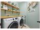 Efficient laundry room with modern washer and dryer, wooden countertop, and ample storage shelves at 1721 Lakelet Loop, Oviedo, FL 32765