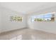 A bright bedroom featuring a terrazzo floor and two windows, showcasing the room's minimalist design and natural light at 1792 Killarney Dr, Winter Park, FL 32789