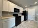 Modern kitchen with white cabinets and black appliances at 193 Grove Branch Rd, Winter Haven, FL 33880