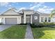 Two-story house with gray siding, stone accents, and a paved walkway at 193 Hampton Loop, Davenport, FL 33837