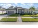 Beautiful two-story home with gray siding, tile roof, and a landscaped lawn at 193 Hampton Loop, Davenport, FL 33837