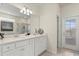 Bright bathroom features double vanity, quartz countertops, decorative accents, and a glass door leading to an outdoor pool area at 1986 Summer Dr, Davenport, FL 33897