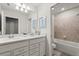Bright bathroom featuring double sinks, white cabinets, and a shower-tub combo at 1986 Summer Dr, Davenport, FL 33897