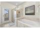 Bathroom featuring a soaking tub, walk-in shower, and a view to the exterior at 1986 Summer Dr, Davenport, FL 33897