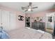 Bedroom featuring pink walls, ceiling fan, and ample natural light with an attached bathroom at 1986 Summer Dr, Davenport, FL 33897
