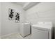 Well-lit laundry room featuring a washer, dryer, and wire shelving for organization at 1986 Summer Dr, Davenport, FL 33897