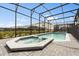 Screened-in pool and spa combination, surrounded by brick pavers and lush landscaping at 1986 Summer Dr, Davenport, FL 33897