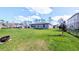 Large backyard with lush green grass and a view of the home's exterior at 2016 West Pkwy, Deland, FL 32724