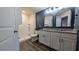 Beautiful bathroom featuring double granite vanity, wood flooring, and shower with white tile surround at 2016 West Pkwy, Deland, FL 32724