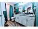 Bathroom with double vanity, granite countertop, framed mirrors, wood-look flooring, and shower at 2016 West Pkwy, Deland, FL 32724