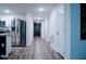 Hallway leading from the kitchen area showing built-in storage, stainless refrigerator and front door at 2016 West Pkwy, Deland, FL 32724