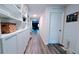 Bright hallway with wood floors, built in white shelving units, and white doors at 2016 West Pkwy, Deland, FL 32724