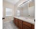 Bathroom with double sinks, wood cabinets, and a large mirror at 2078 Marsh Hawk Dr, Orlando, FL 32837