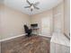 Well-lit bedroom with wood-look floors, window blinds, and a workspace at 2078 Marsh Hawk Dr, Orlando, FL 32837