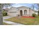 One-story house with beige exterior, two-car garage, and landscaping at 2078 Marsh Hawk Dr, Orlando, FL 32837