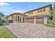 Three-car garage with paver driveway and stone accents at 2185 Talman Court, Winter Park, FL 32792