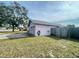 Side yard view showcasing a pink house with an attached garage at 282 W Summit St, Apopka, FL 32712