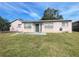 Back exterior of the house with a patio and grassy backyard at 282 W Summit St, Apopka, FL 32712