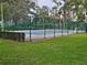 Fenced tennis court surrounded by lush landscaping at 306 Northlake Dr # 306, Sanford, FL 32773