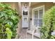 Inviting front porch with two chairs, lush greenery, and a white front door at 3264 River Branch Cir, Kissimmee, FL 34741