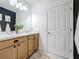 Bathroom with double vanity, wood cabinets, and a large mirror at 429 Tisone Ln, Davenport, FL 33837