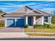 Two-car garage, light gray exterior, and blue doors at 4462 Lions Gate Ave, Clermont, FL 34711