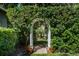 Charming garden path with a white arbor and lush greenery at 4847 Shoreline Cir, Sanford, FL 32771