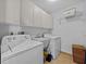 Bright laundry room with washer, dryer, and cabinets at 6541 Fairway Hill Ct, Orlando, FL 32835